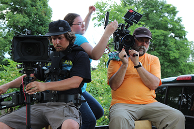 Liberty cinematic arts graduates Ian Miller (left) and Marissa Scalzo work alongside 'Texas Rein' director of photography and LU professor Doug Miller on set.