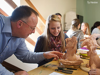 Liberty students sculpting under the direction of an instructor.