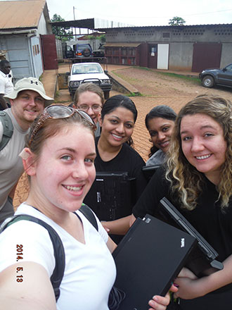 Liberty students present laptops to workers in Cameroon.