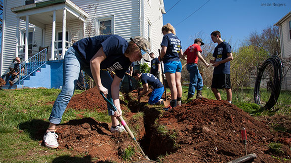 Liberty University students work together to dig a trench during one of several Love on Lynchburg Day projects.