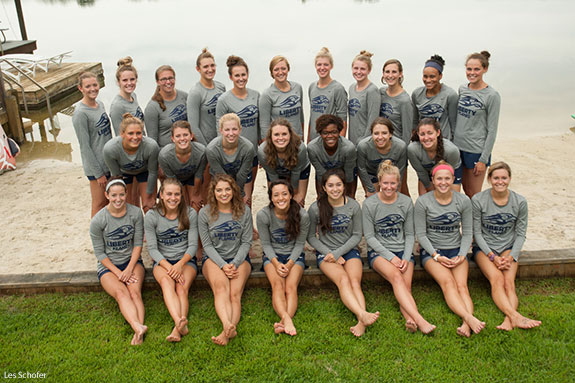 Members of Liberty University's NCAA Division I women's swim team pose from the beach of the Falwell's farm lake.