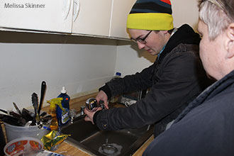A Liberty University student installs a water filter in the home of a Flint, Mich., resident.