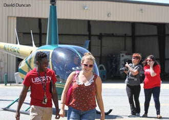 Volunteers mingle with visitors in front of the helicopter featured at Women Can Fly. 
