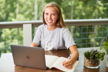 LUOA student working outside on laptop