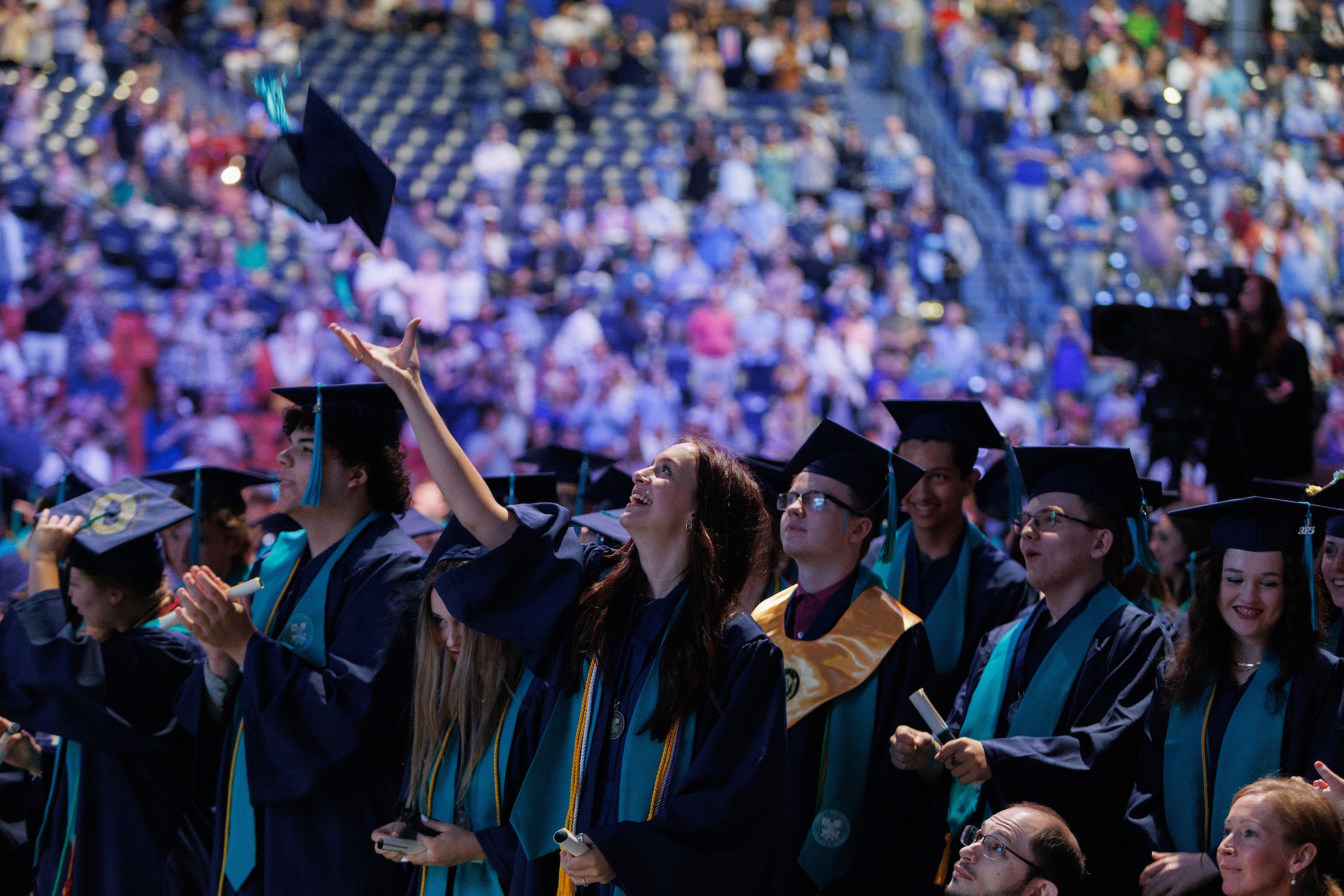 Female LUOA student tossing her graduation cap during the commencement ceremony