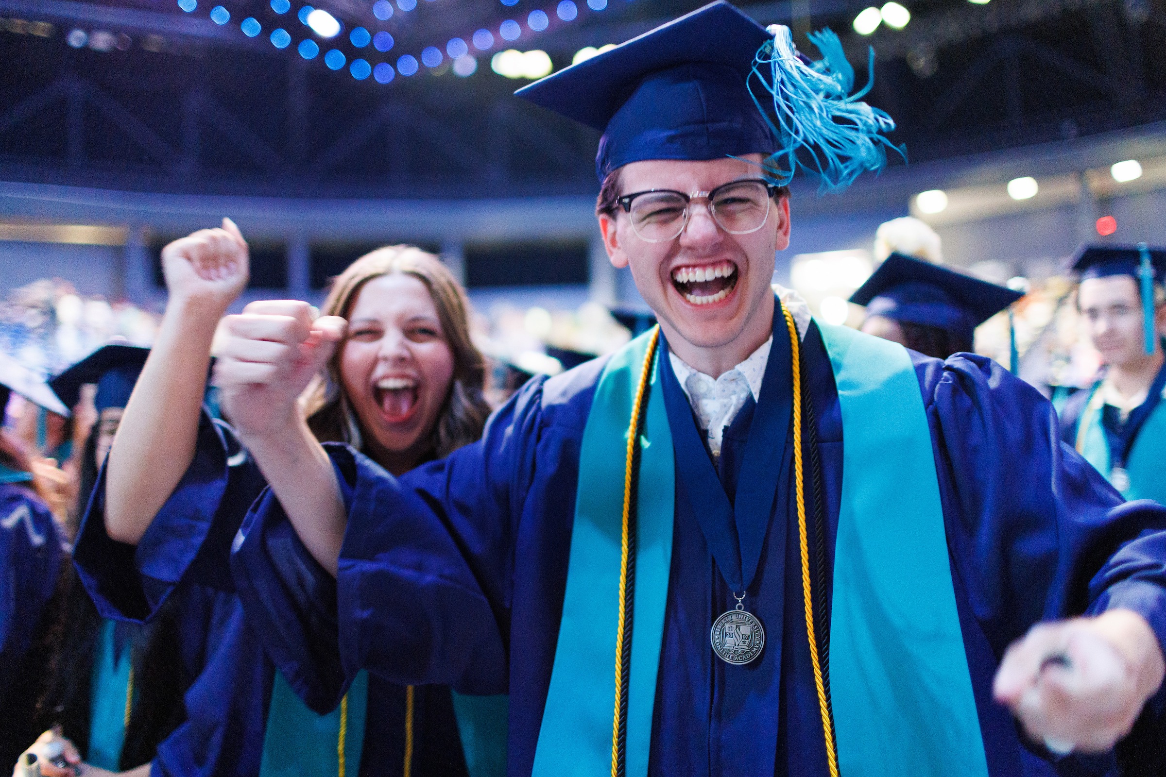 LUOA graduate smiling at the camera and pumping his fist