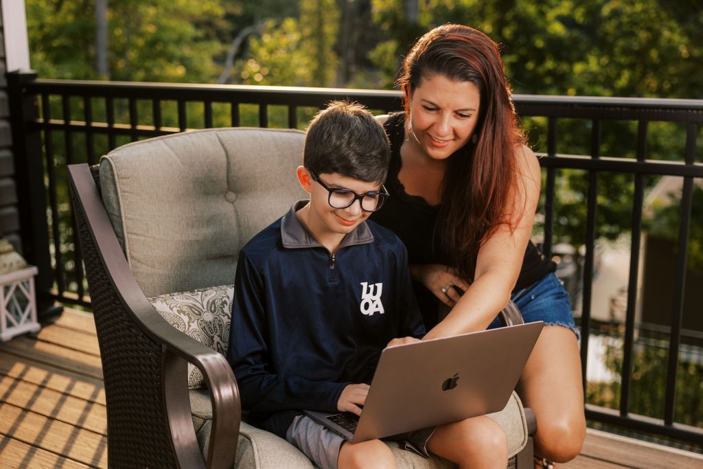 A parent and their student looking at Ember syllabi on a laptop