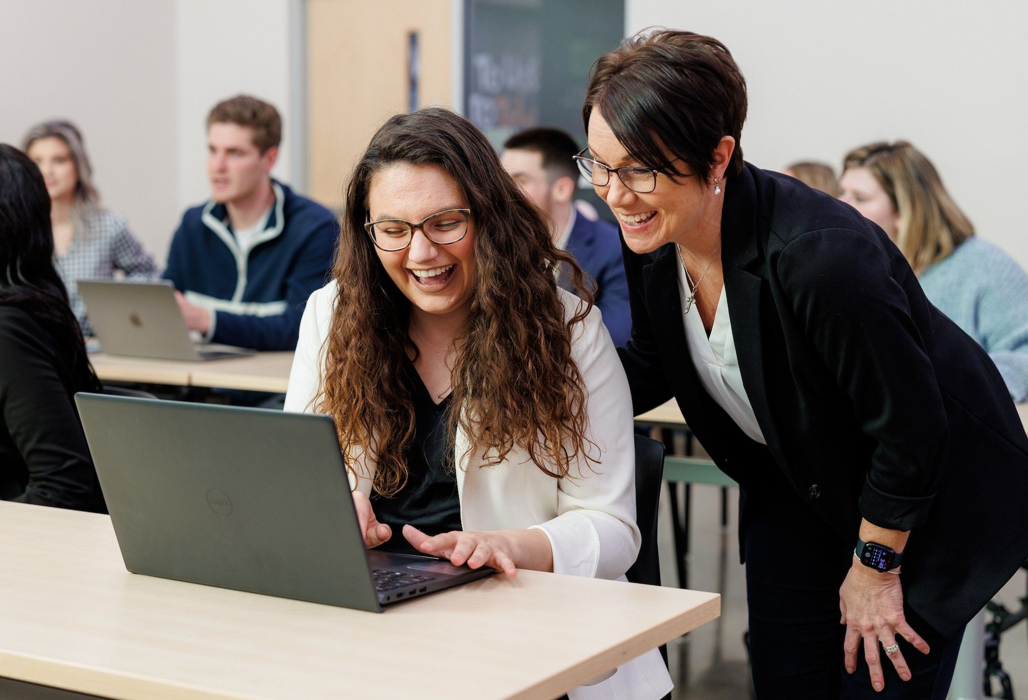 An advertising professor helps a student with a class exercise