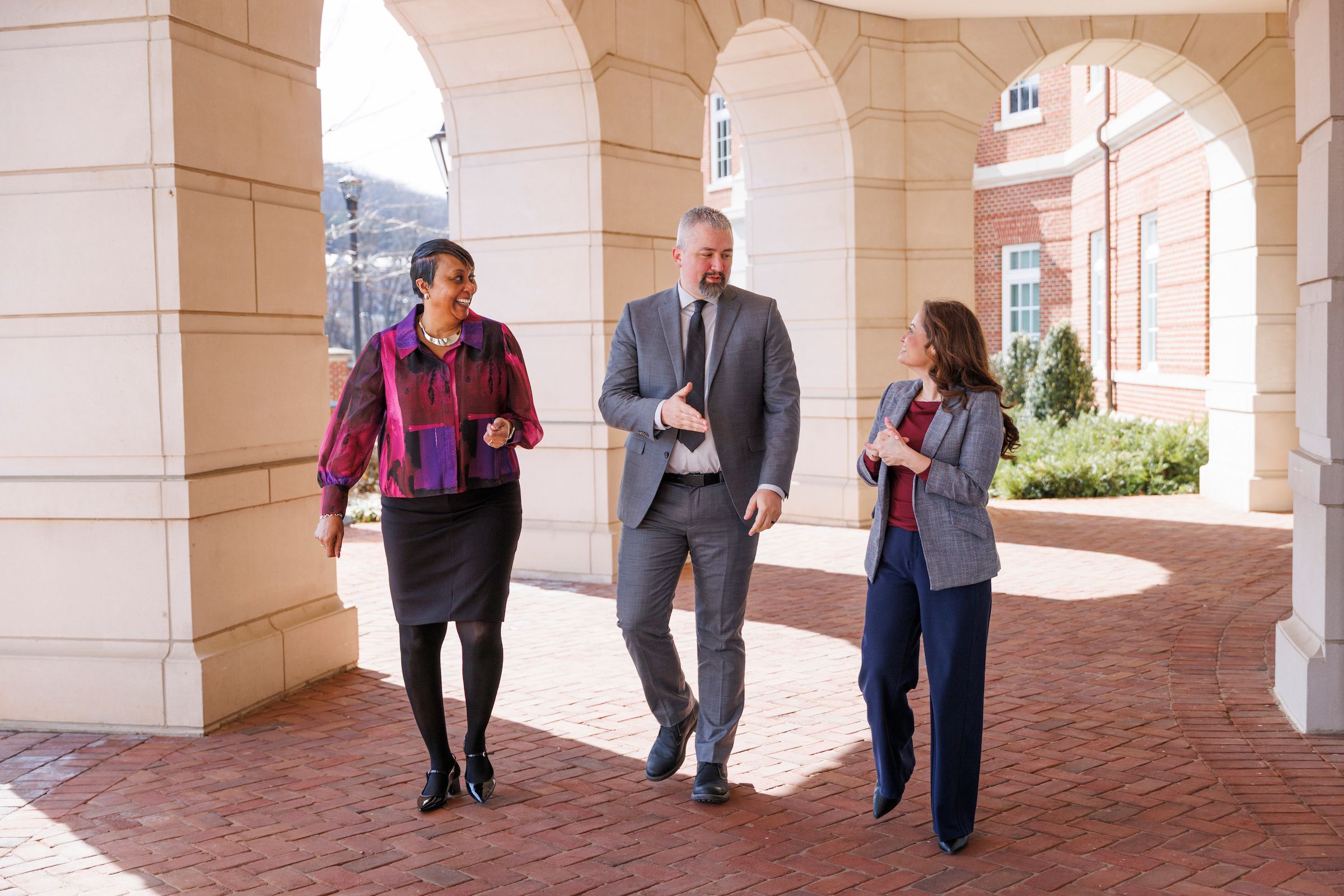 Three higher education registrar services employees walking on Liberty University's campus
