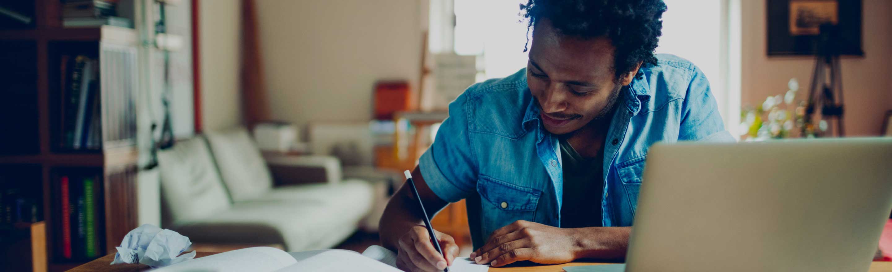 Smiling man working on homework at his desk