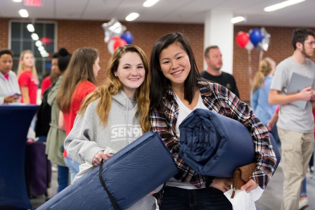 Two Young Women Attending Cfaw Holding Supplies